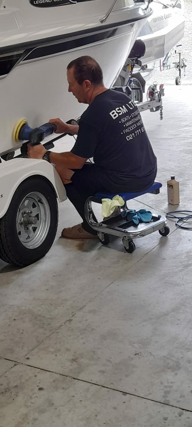 BSM technician machine polishing the hull of a boat